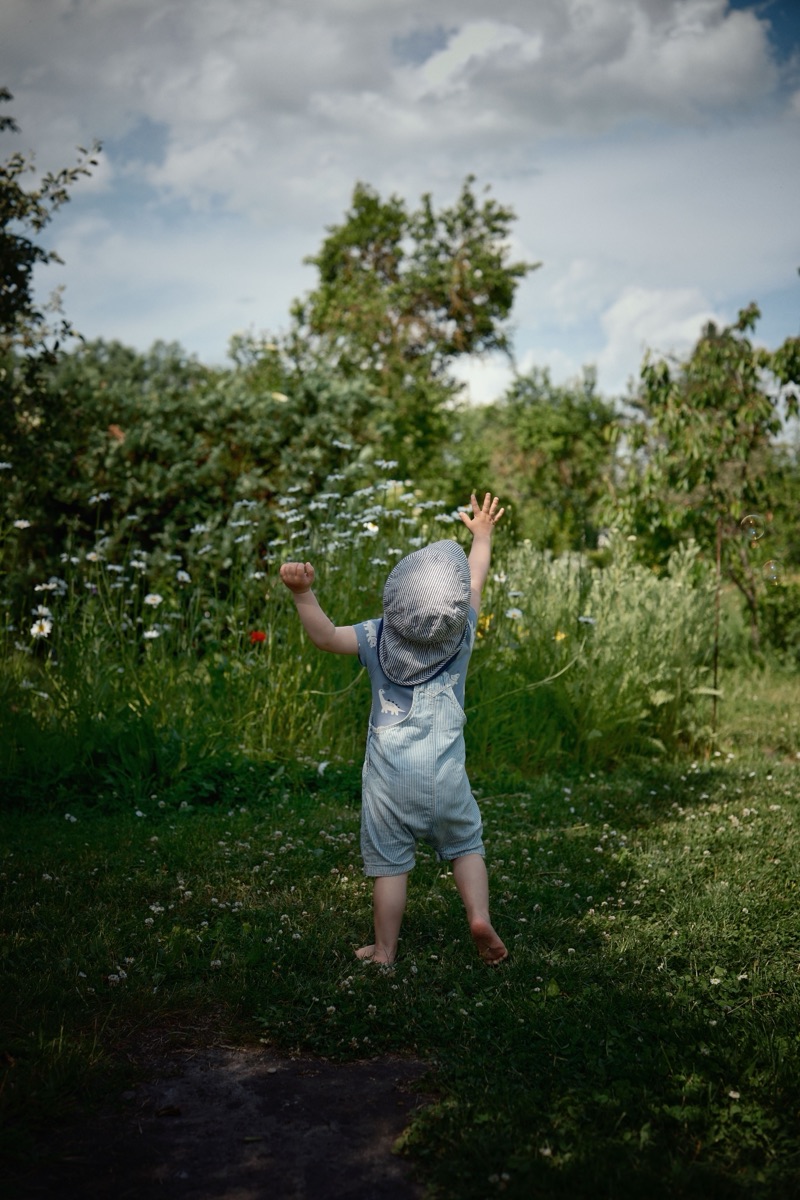 A toddler mid-stride outdoors.